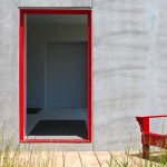 porta rossa d'entrata con una adirondack chair